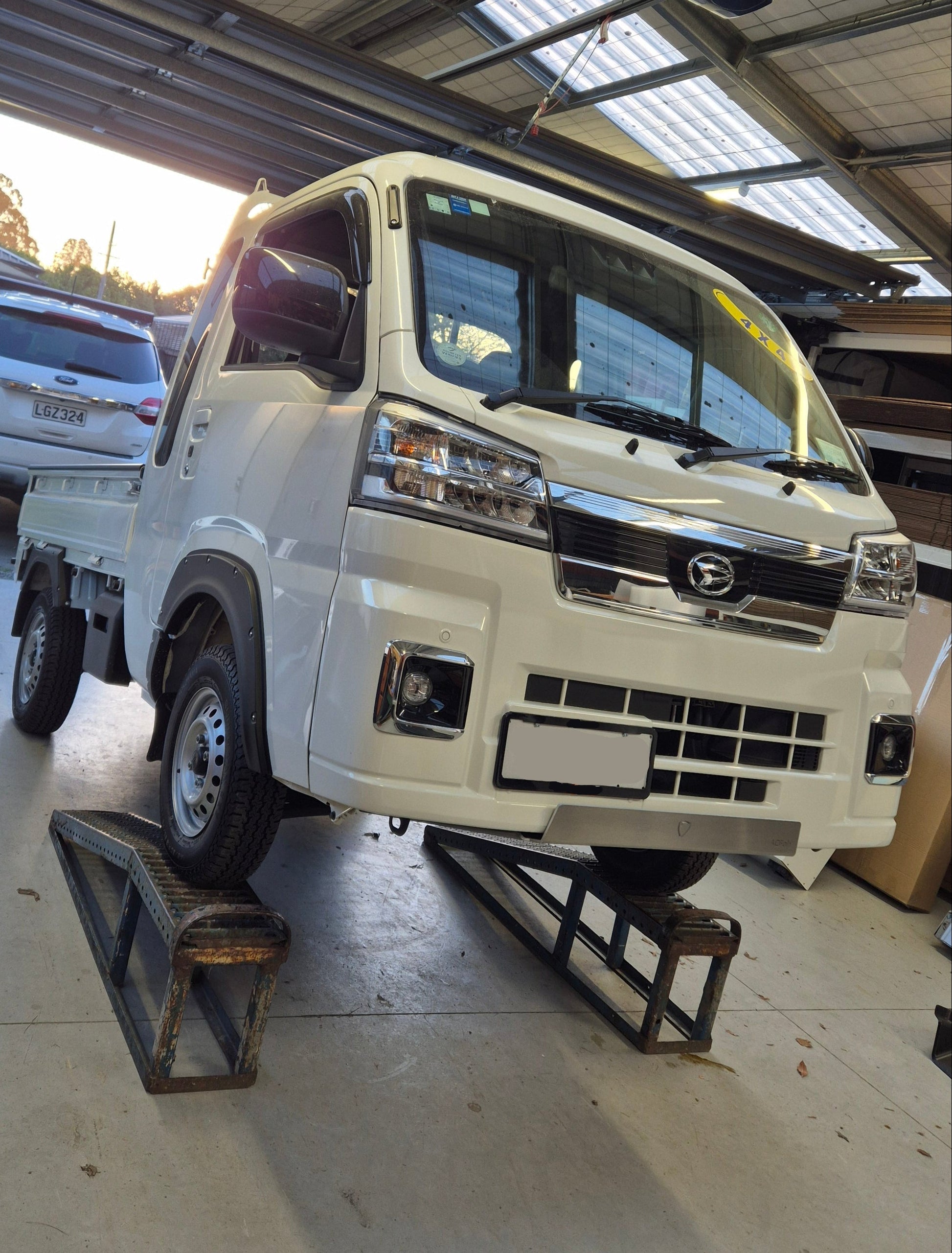 White truck with 'Daihatsu' branding inside a building